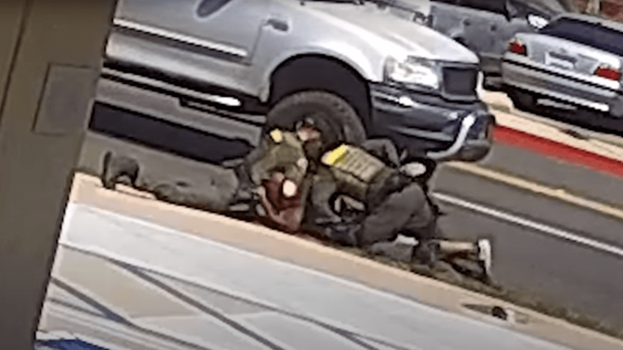 man being wrestled to the ground on the side of the road by two sheriff's deputies