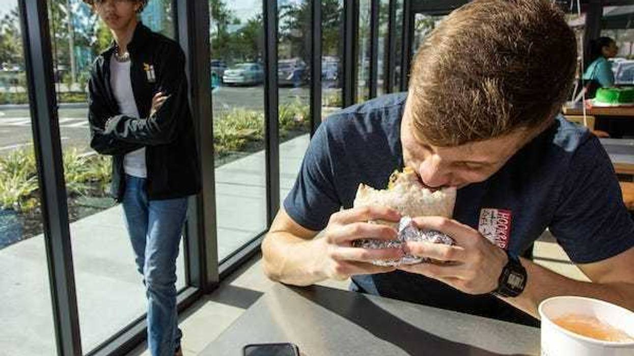 Man biting a burrito at Chipotle