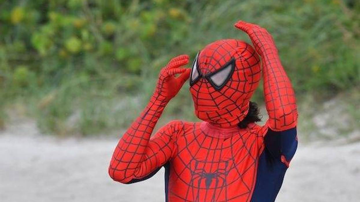 Man dressed in Spider-Man costume on the beach