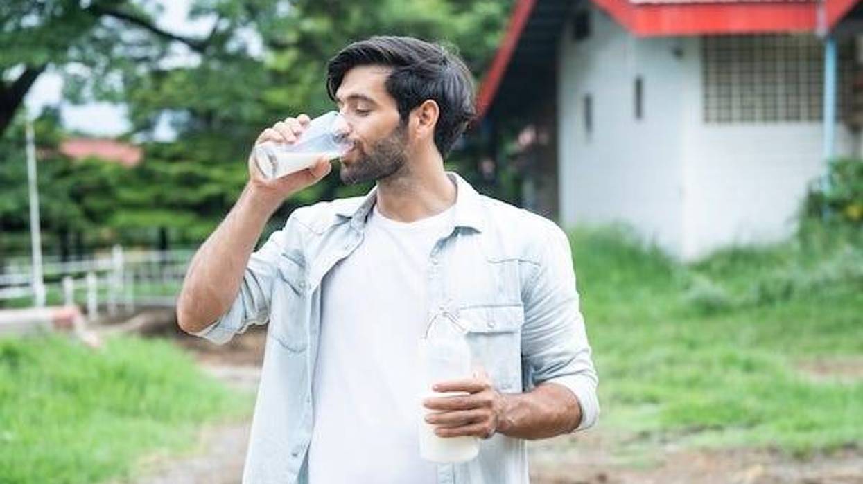 Man drinking milk while standing outside