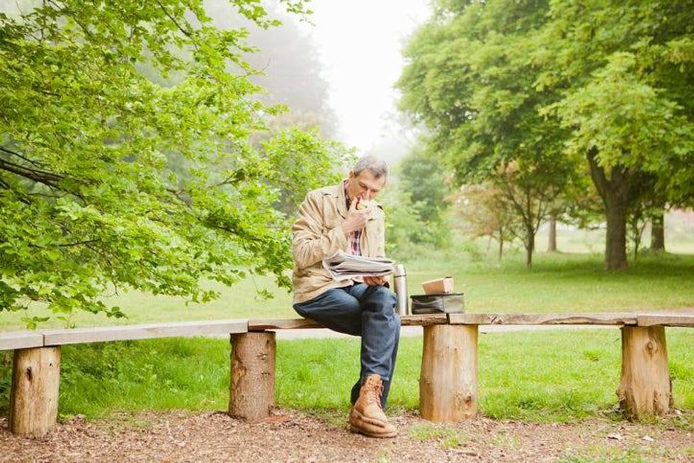 Man Eating Lunch On Park Bench