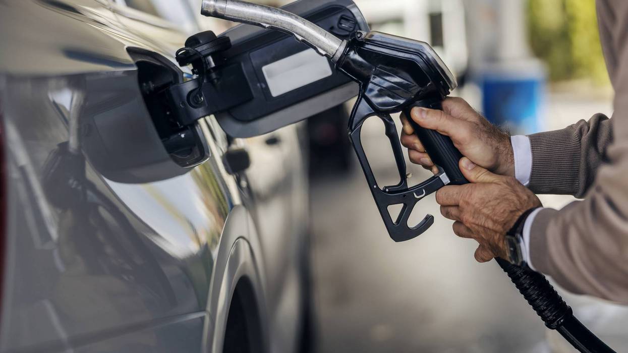 Man fueling car at gas station pump