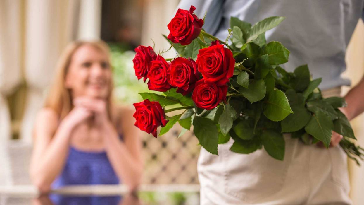 Man giving woman flowers stock photo.