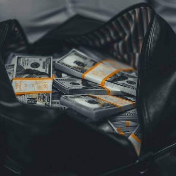 Man holding a duffle bag full of cash