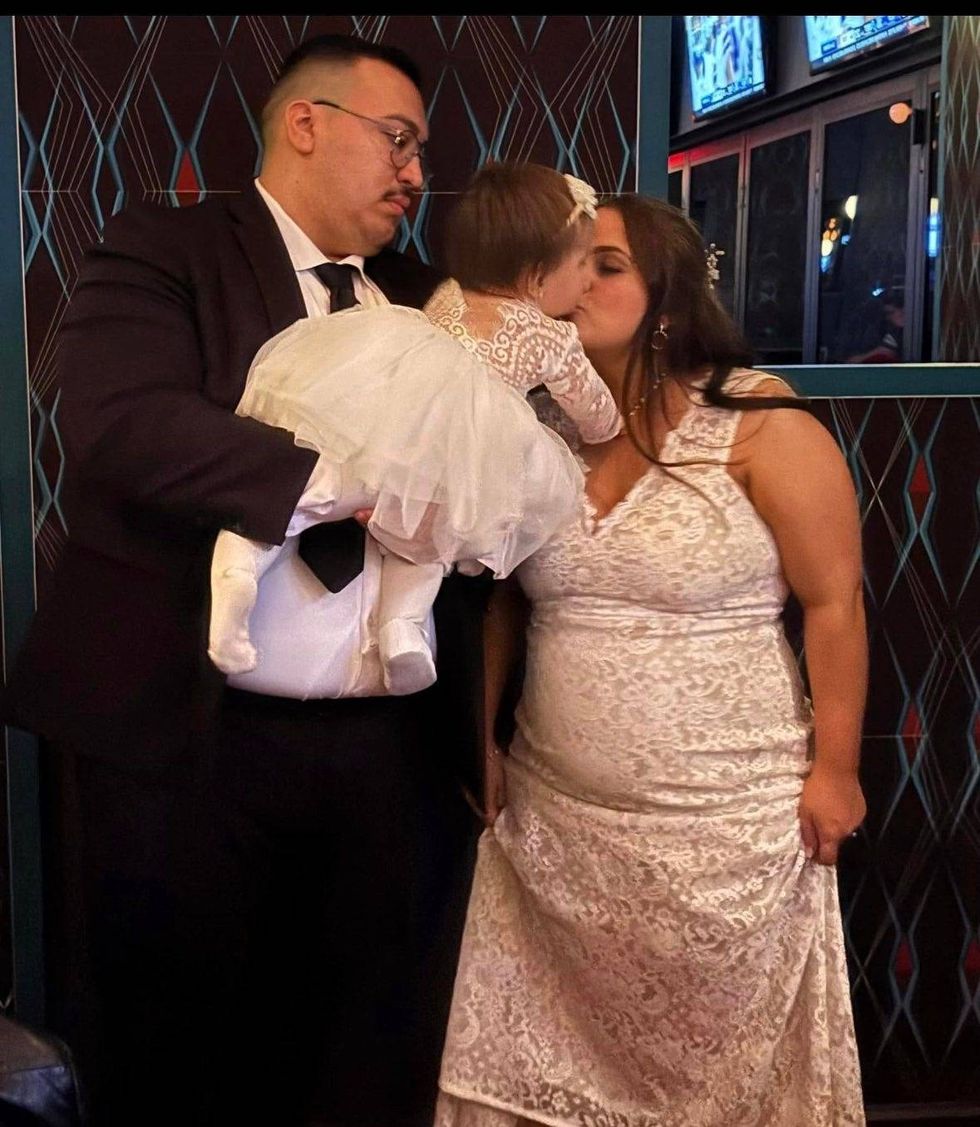 Man holding baby, woman kissing baby