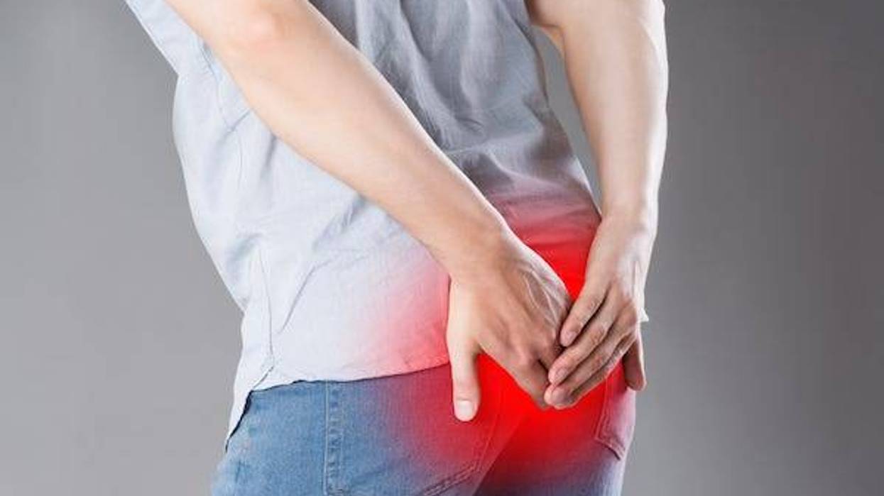 Man holding butt in pain