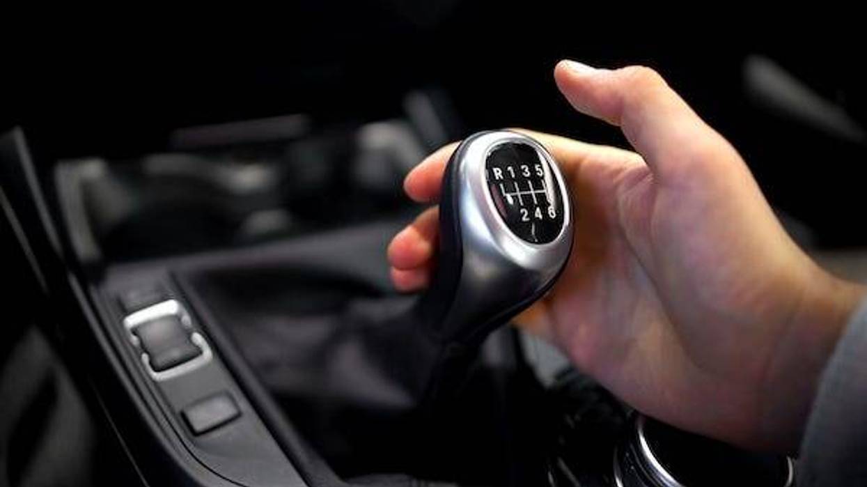 Man holding manual stick shift in car