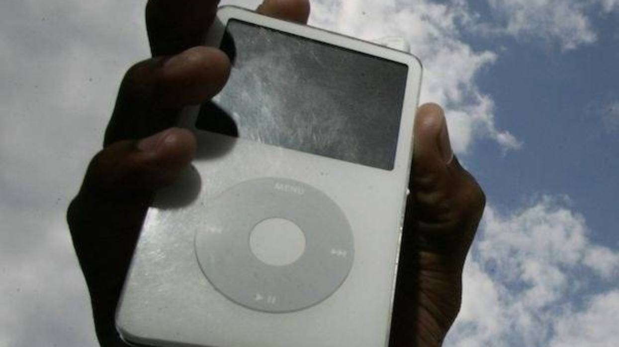Man holds iPod in the air against cloudy sky