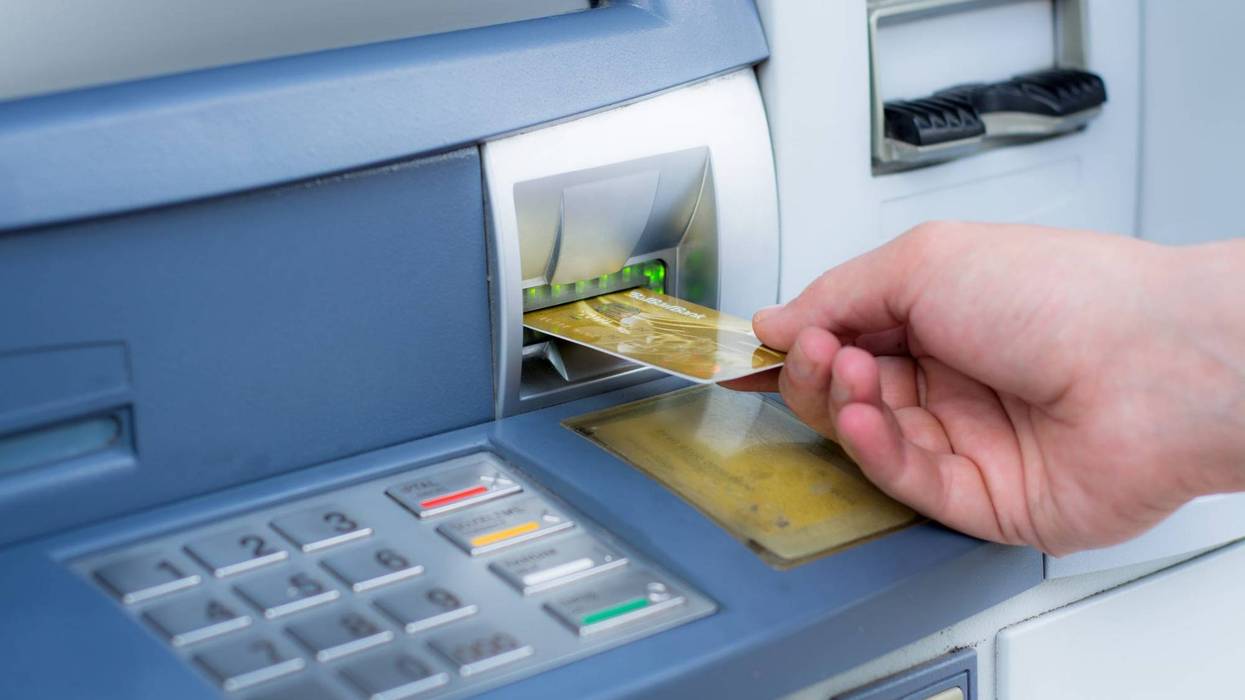 man inserts card into ATM