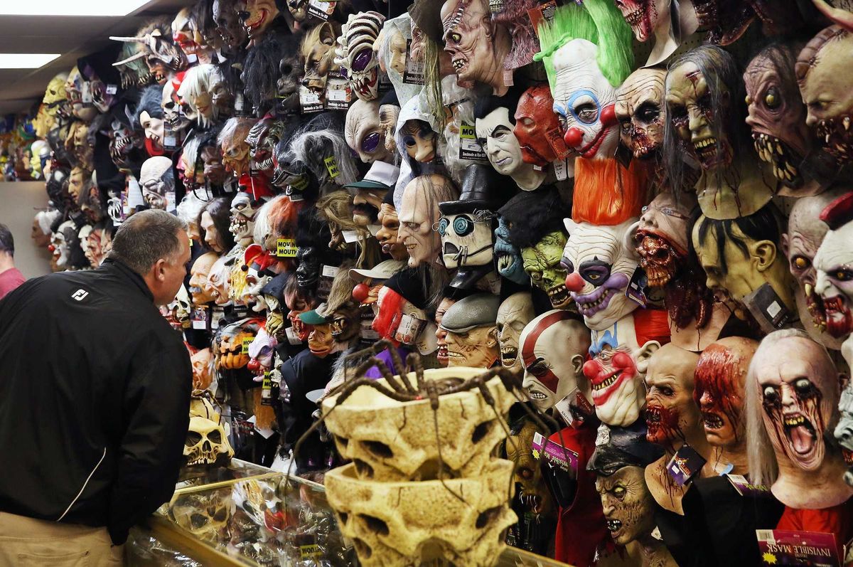 Man looking at masks inside Halloween store