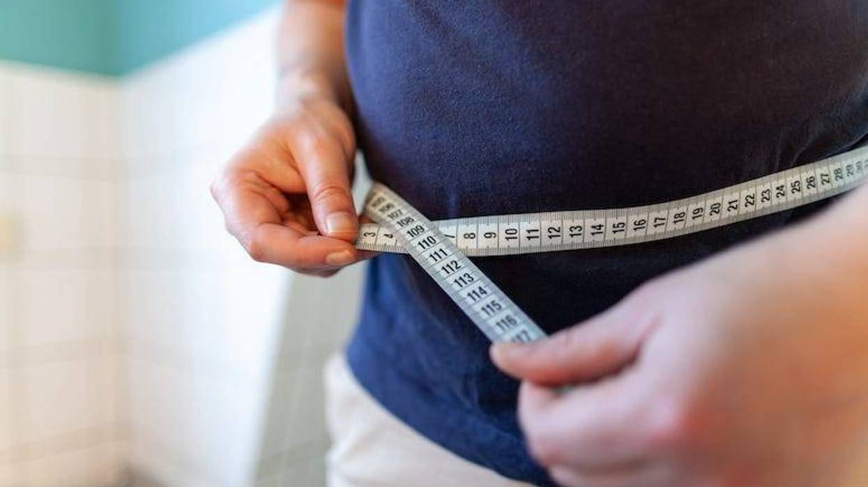 Man measuring belly with measuring tape