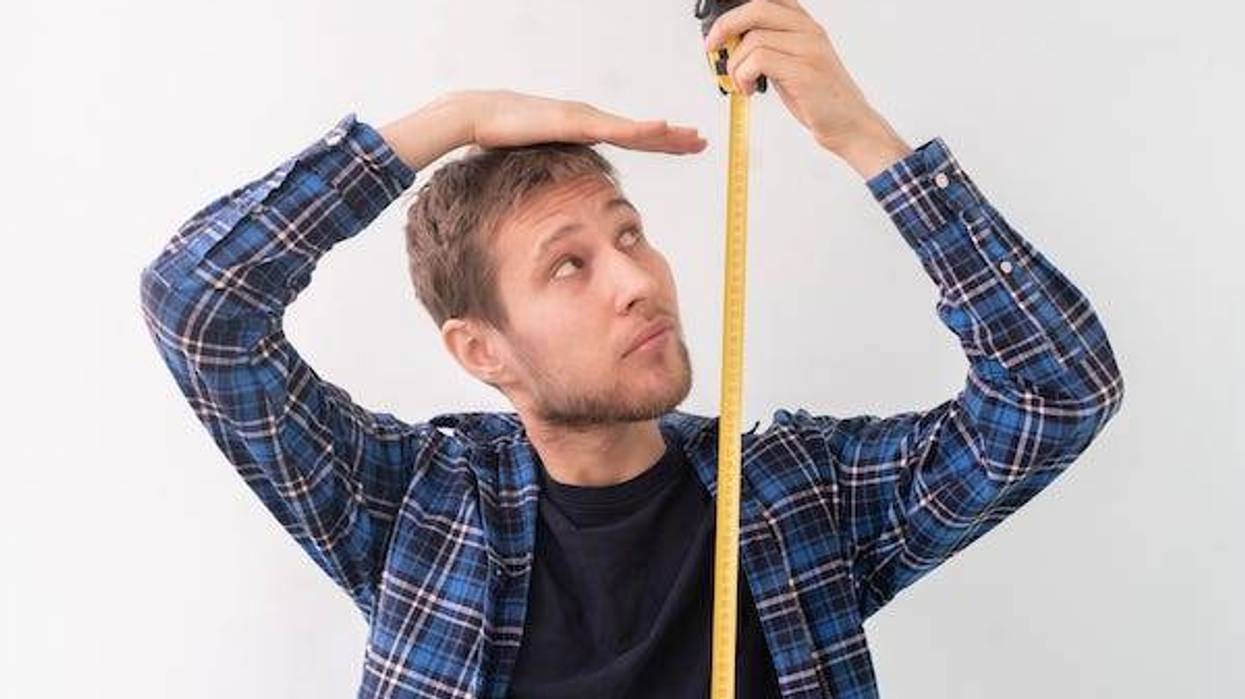 Man measuring height with tape measure