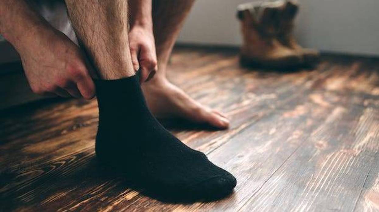 Man putting on black socks