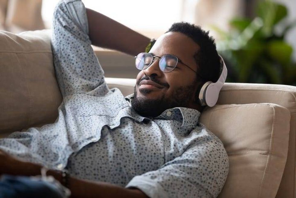 Man Relaxing On Couch With Headphones
