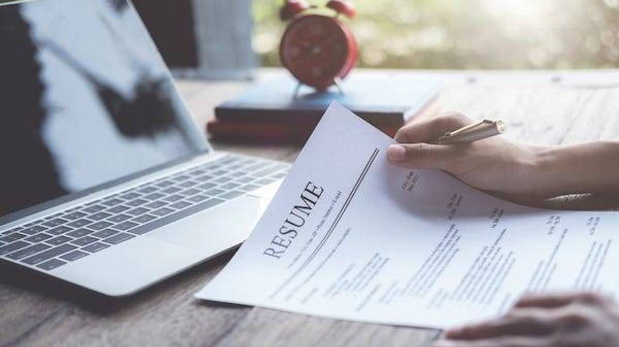 Man reviews his résumé at his desk