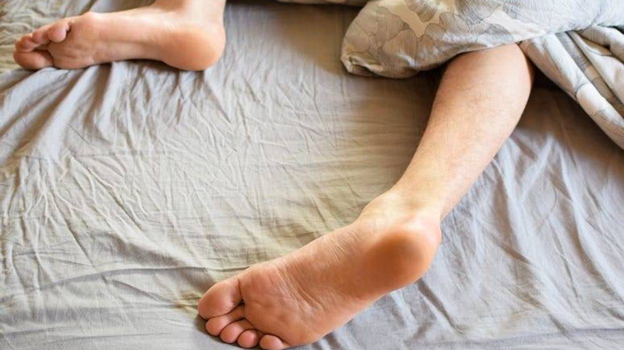 Man's feet sleeping on bed