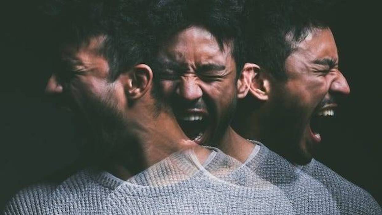 Man screaming against a black background