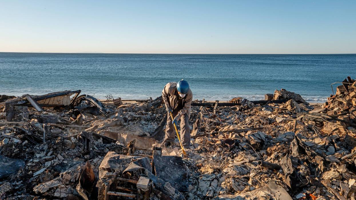 man sifting through rubble