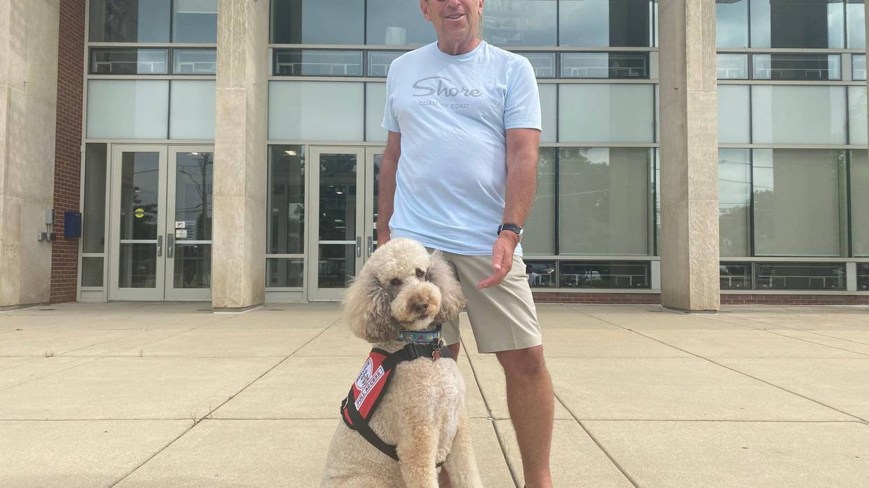 Man stands with dog outside Highland Park High School