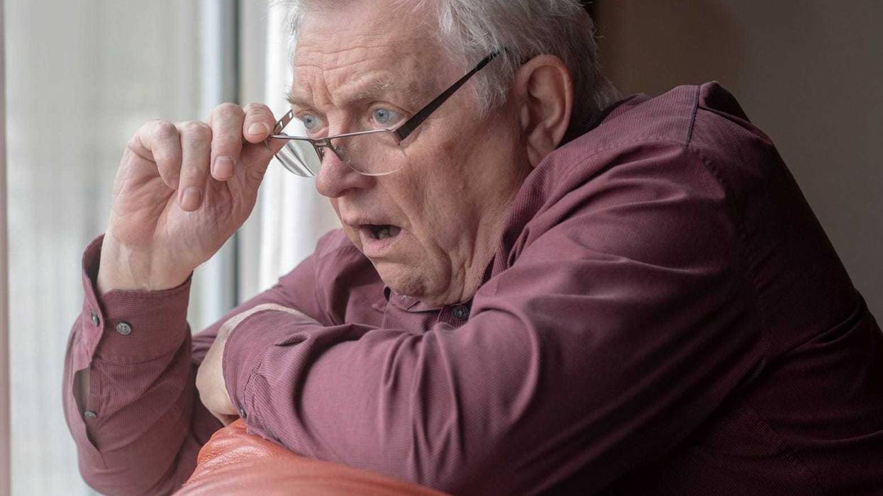Man staring out window stock photo.