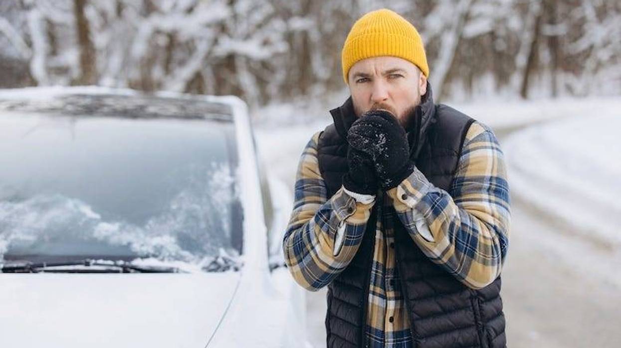 Man stranded on the side of the road during a snowstorm