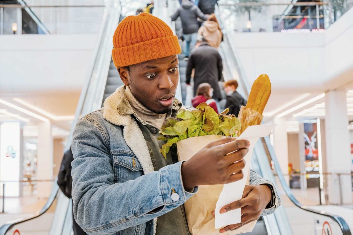 Man surprised at grocery prices stock photo.