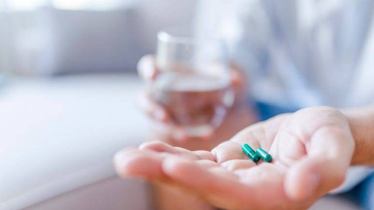 Man taking pills with a glass of water