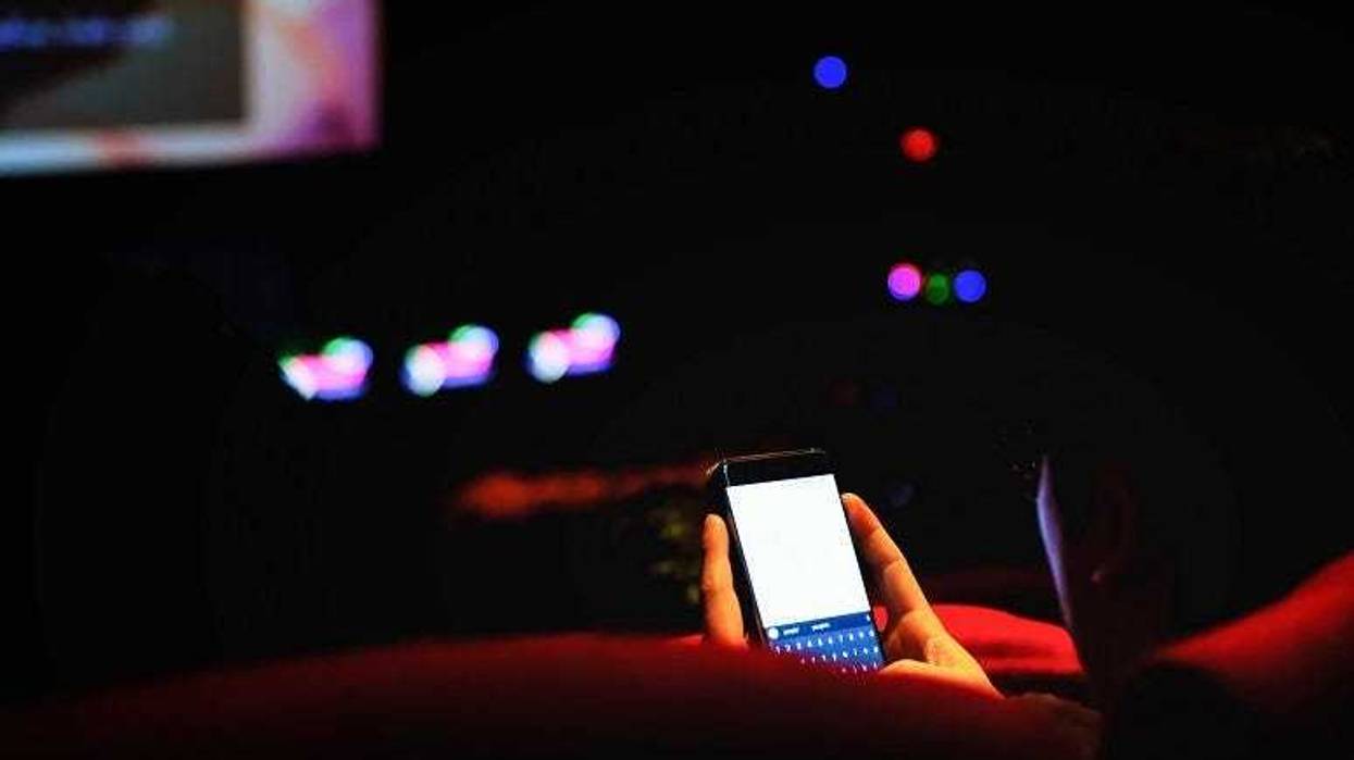 Man using cell phone in a movie theater