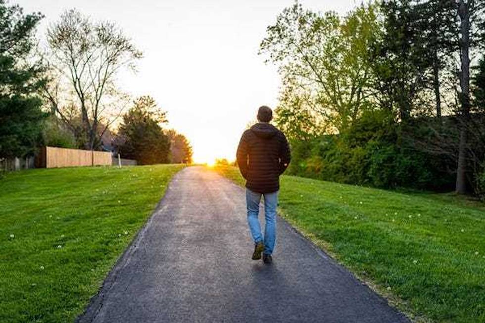 Man walking on an outdoor trail during sunset
