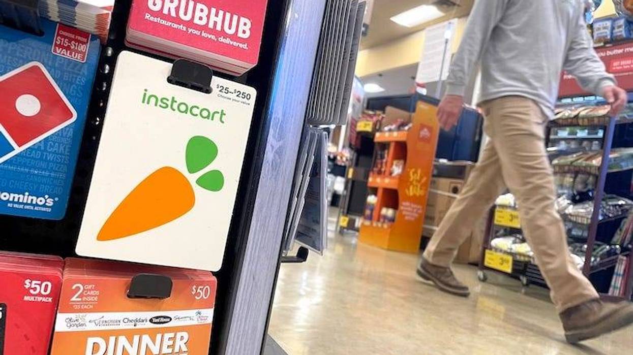 Man walking past a gift card display