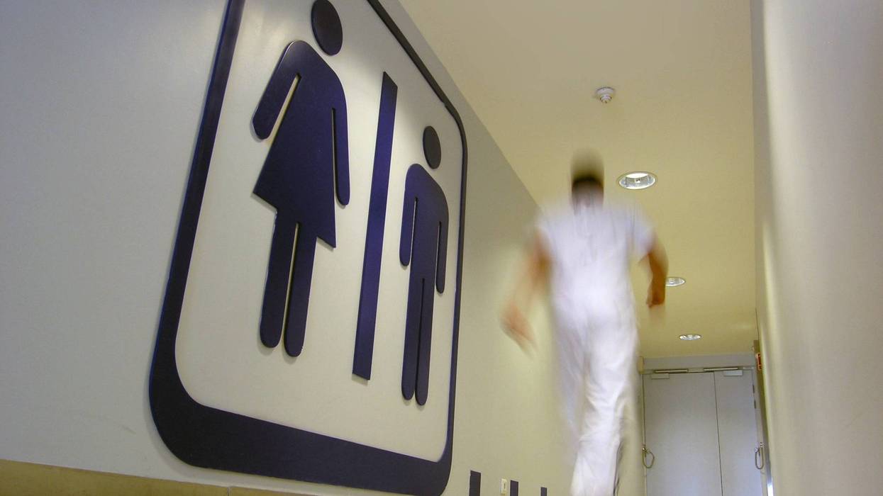 Man walking swiftly into gender-neutral public restroom