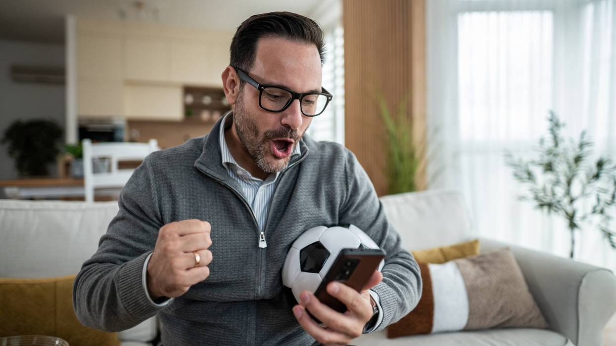 Man watching football on smartphone feeling excited