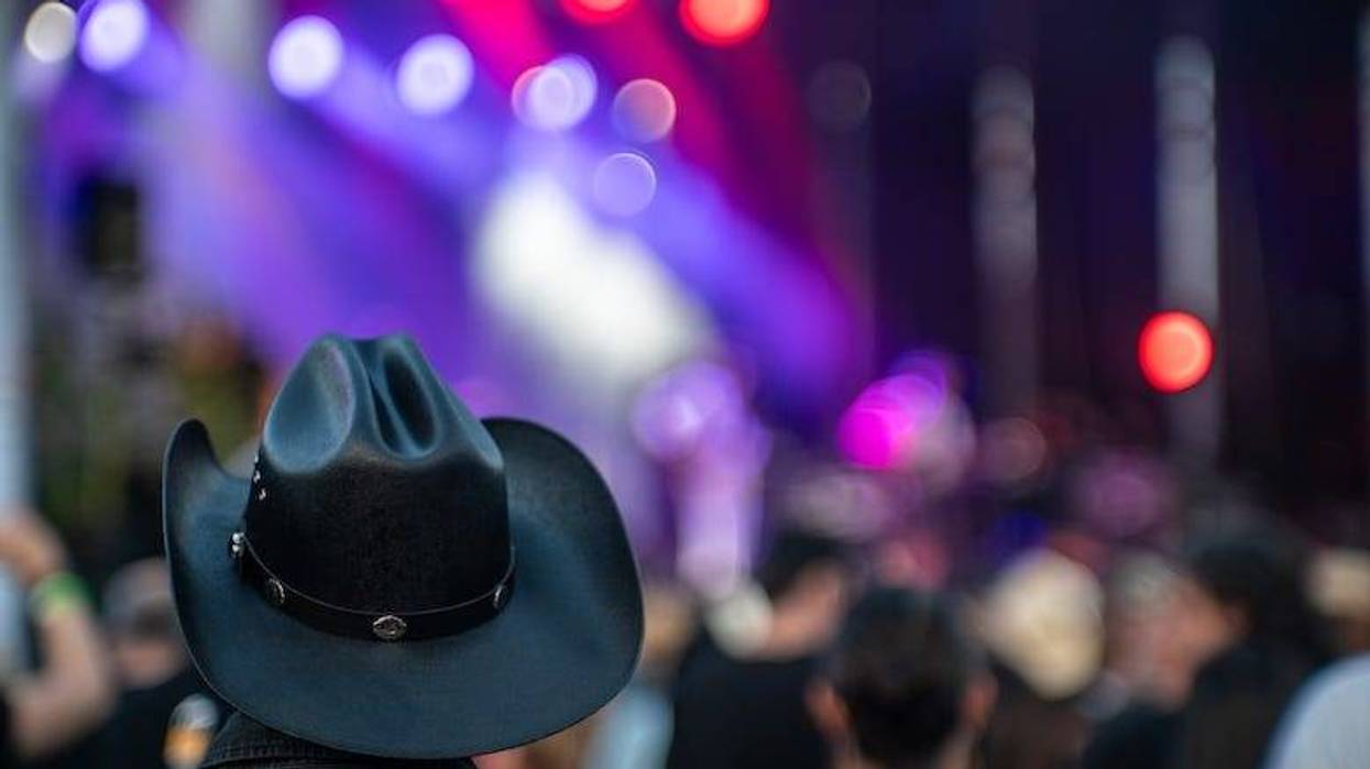 Man wearing a black cowboy hat watching a crowd