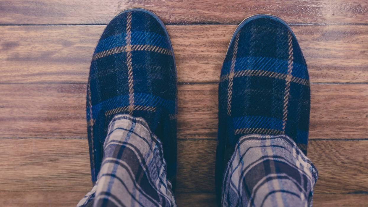 Man wearing pajamas and slippers on hardwood floor