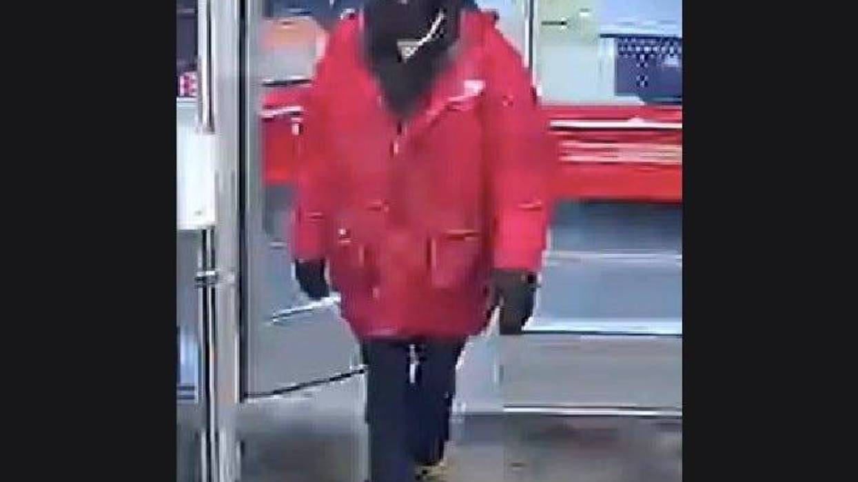 Man wearing red winter coat and black ski mask