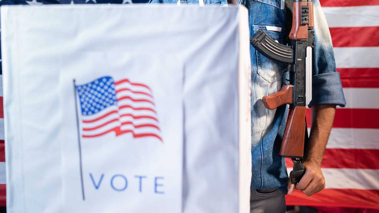 Man with a gun at a voting booth, in front of an American flag.