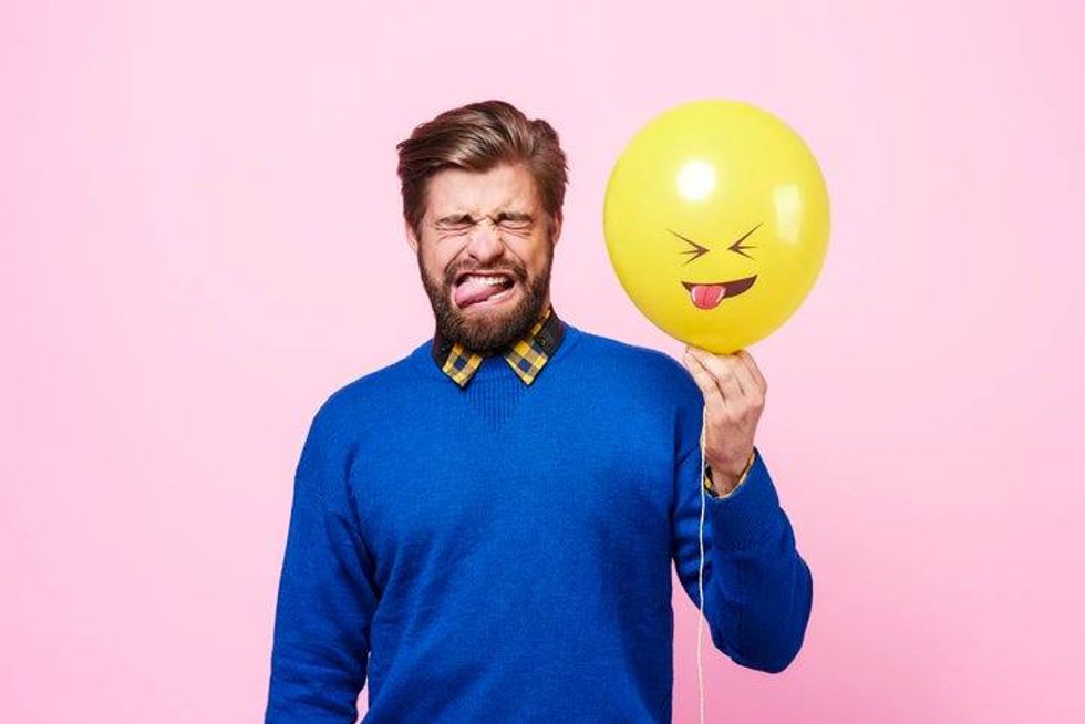Man with balloon making a yuck face
