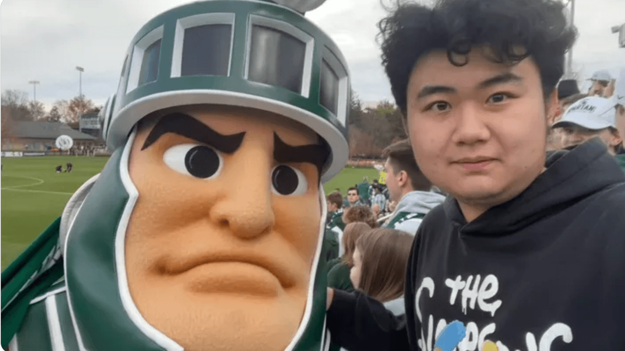 Man with Spartan in front of football field