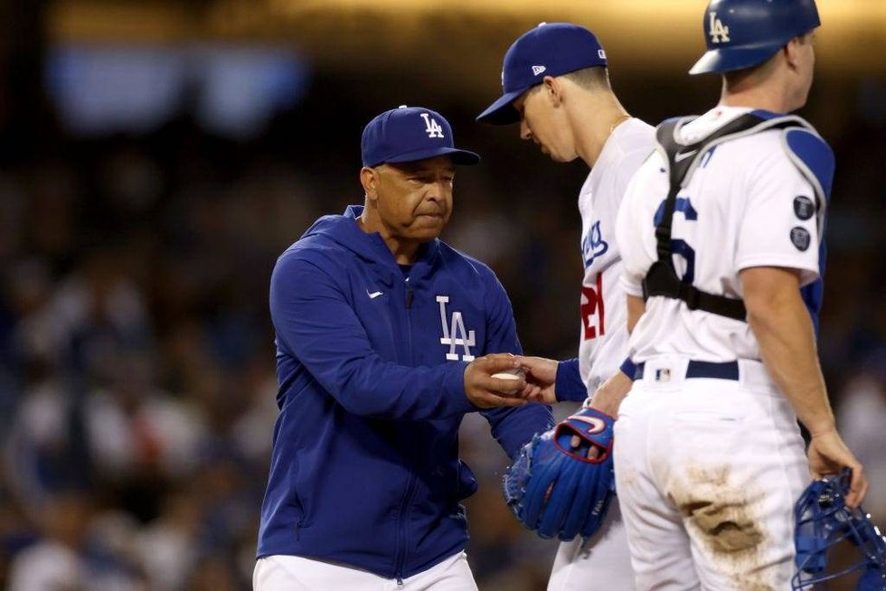 Manager Dave Roberts #30 takes out Walker Buehler #21 of the Los Angeles Dodgers against the San Francisco Giants during the fifth inning in game 4.