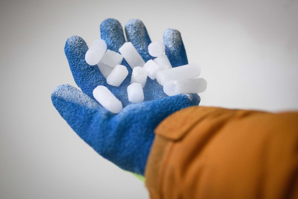 Managing Director Nilesh Acharya handles a fresh production of coarse dry ice pellets at the Dry Ice Nationwide manufacturing facility on November 11, 2020 in Reading, England.