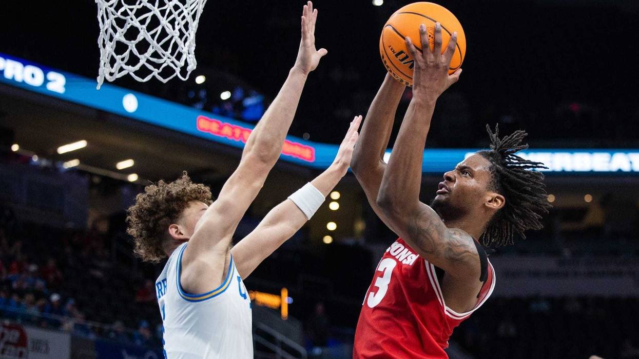 Mar 14, 2025; Indianapolis, IN, USA; Wisconsin Badgers forward Xavier Amos (13) shoots the ball while UCLA Bruins guard Trent Perry (1) defends in the second half at Gainbridge Fieldhouse. Mandatory Credit: Trevor Ruszkowski-Imagn Images