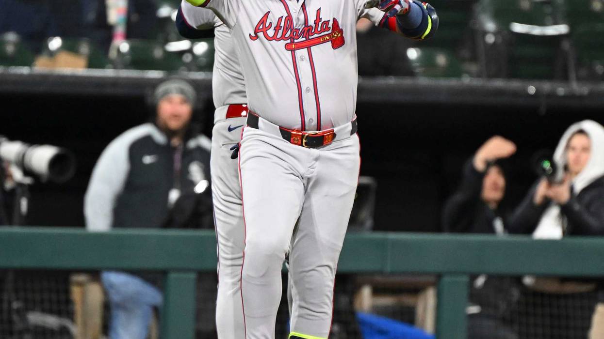 Marcell Ozuna #20 of the Atlanta Braves is congratulated by third base coach Matt Tuiasosopo #89 of the Atlanta Braves following a home run during the seventh inning of a game against the Chicago White Sox at Guaranteed Rate Field