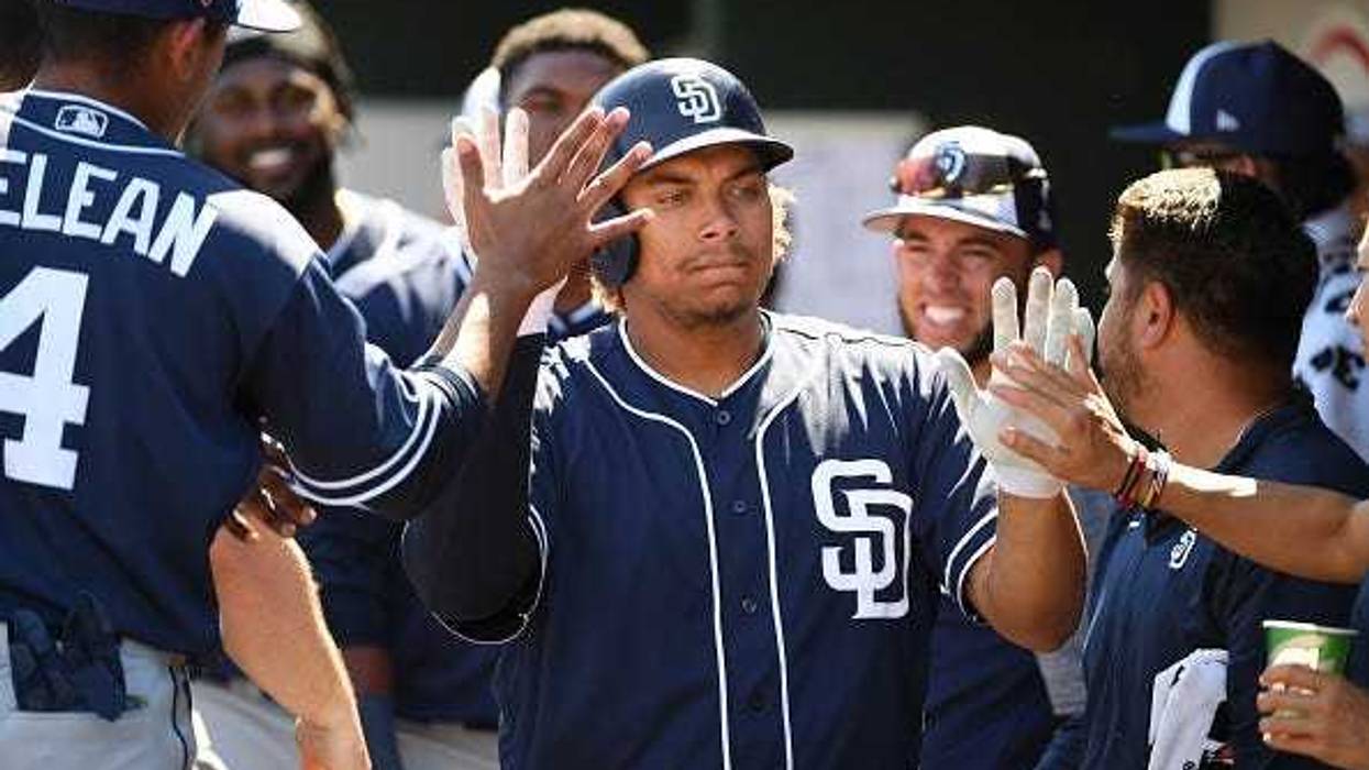 MARCH 18: Josh Naylor #87 of the San Diego Padres celebrates with teammates in the dugout after hitting a solo home run during the second inning of a spring training game against the Cleveland Indians at Goodyear Ballpark on March 18, 2019 in Goodyear, Ar