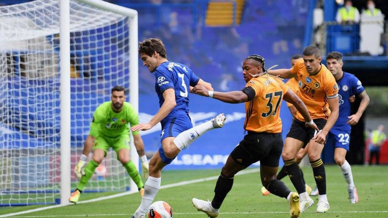 Marcos Alonso of Chelsea battles for possession with Adama Traore of Wolverhampton Wanderers during the Premier League match between Chelsea FC and Wolverhampton Wanderers at Stamford Bridge on July 26, 2020 in London, England. Football Stadiums around Europe remain empty due to the Coronavirus Pandemic as Government social distancing laws prohibit fans inside venues resulting in all fixtures being played behind closed doors.
