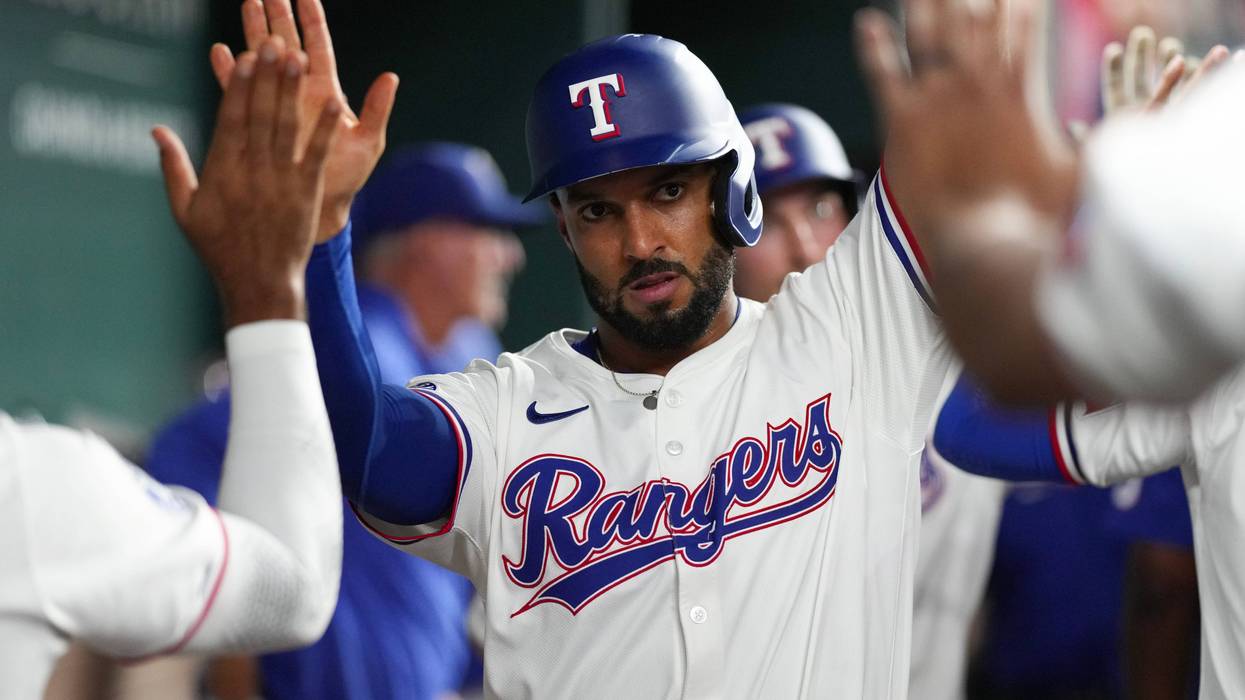 Marcus Semien #2 of the Texas Rangers is congratulated in his dugout after scoring a run during the fourth inning against the Toronto Blue Jays at Globe Life Field on Sept. 17, 2024 in Arlington, Texas.