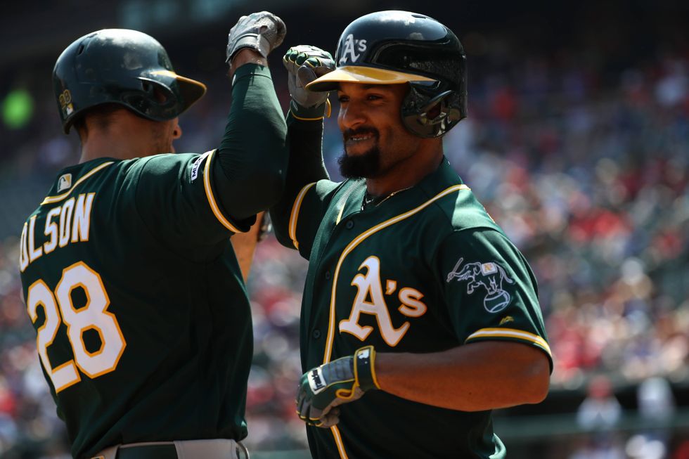 Marcus Semien bumps elbows with teammate Matt Olson