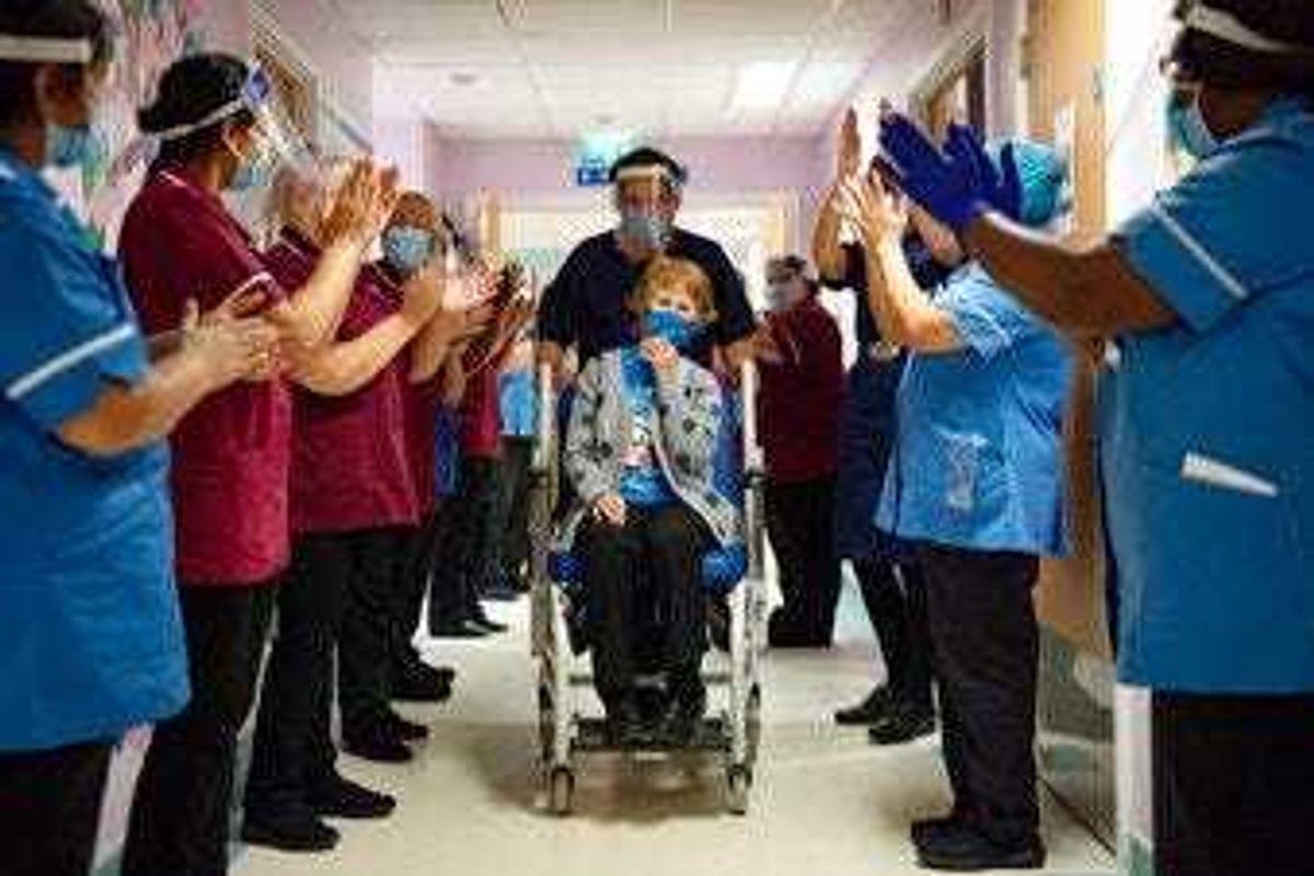 Margaret Keenan, 90, is applauded by staff as she returns to her ward after becoming the first patient in the UK to receive the Pfizer-BioNTech COVID-19 vaccine. (Jacob King/Pool via AP)