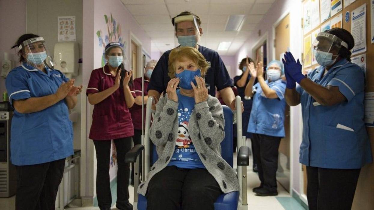 Margaret Keenan, 90, is applauded by staff as she returns to her ward after becoming the first patient in the UK to receive the Pfizer-BioNTech COVID-19 vaccine, at University Hospital, Coventry, England, Tuesday Dec. 8, 2020.