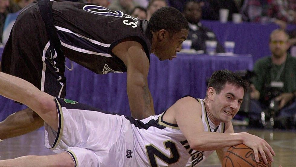 Martin Ingelsby of Notre Dame recovers the loose ball as Lionel Chalmers of Xavier defends during the first round of the 2011 NCAA Men