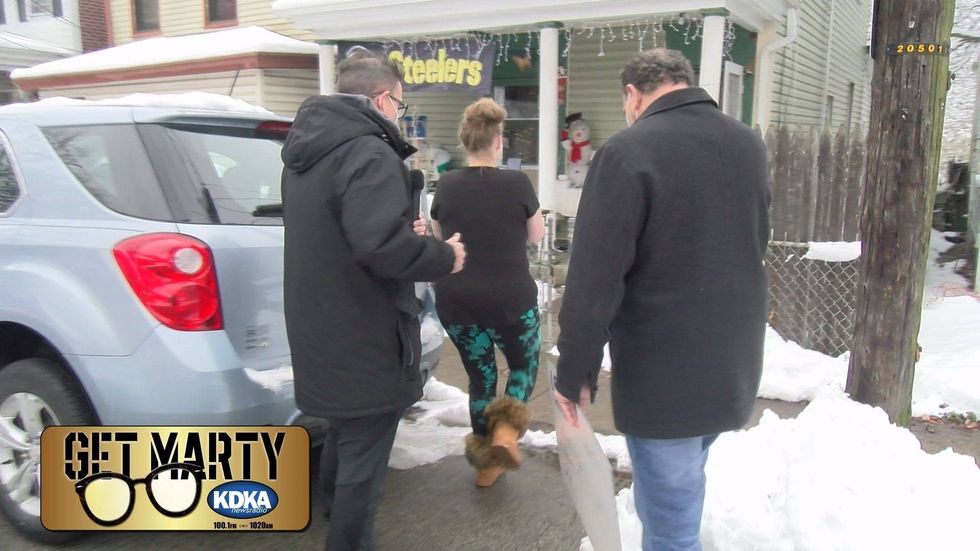 Marty Griffin, Ken Coury from Levin Furniture and Brenda get ready to deliver the surprise.